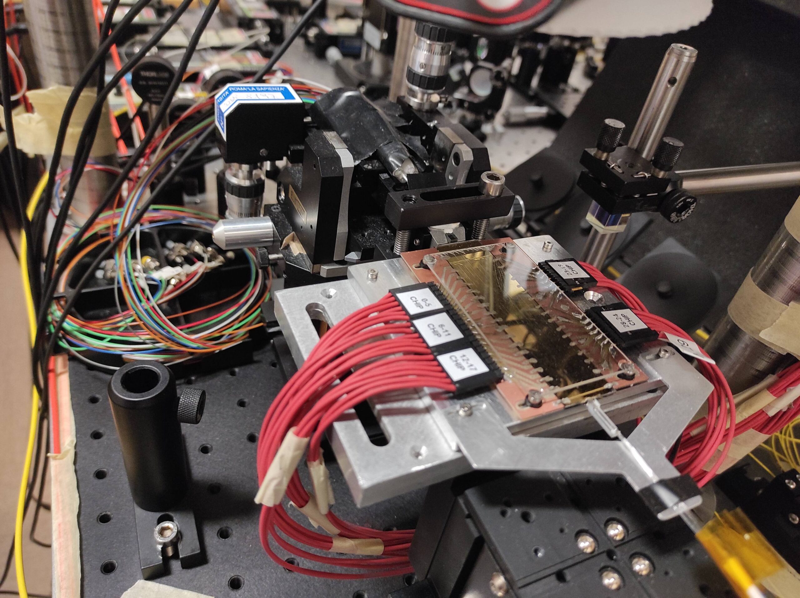 Chip fotonico universale e riprogrammabile che opera su 6 modi, ovvero 6 guide d’onda che interagiscono mediante una rete di beamsplitter integrati. Nella foto il dispositivo e l’elettronica di controllo. Credits: photo by Quantum Lab Sapienza. All rights reserved