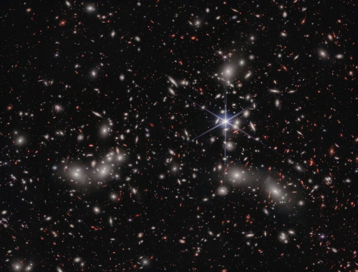 Webb finds dwarf galaxies reionised the Universe small galaxies reionised the Universe A crowded galaxy field on a black background, with one large star dominating the image just right of center. Three areas are concentrated with larger white hazy blobs on the left, lower right, and upper right above the single star. Scattered between these areas are many smaller sources of light; some also have a hazy white glow, while many other are red or orange.