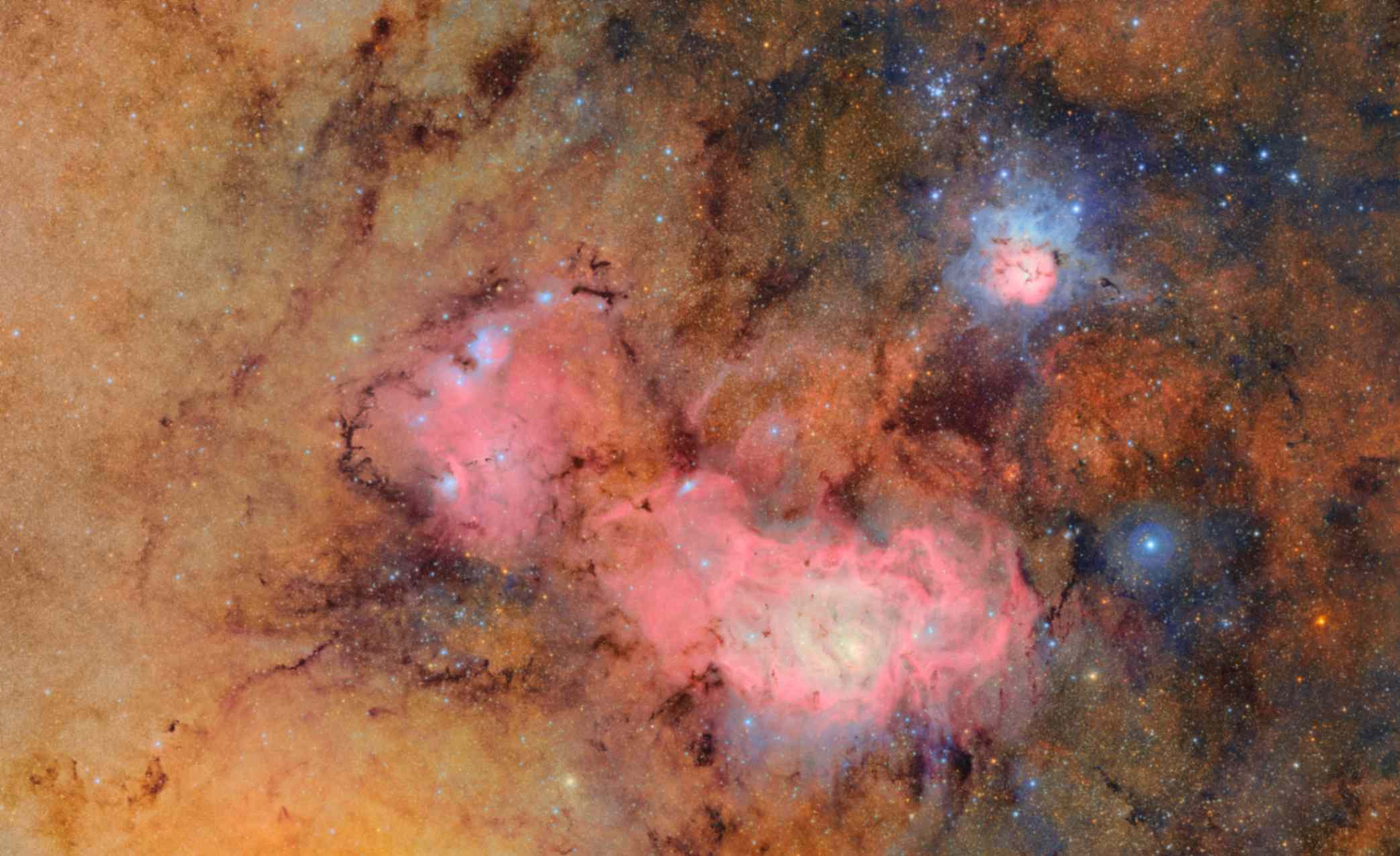 Questa immagine combina 678 scatti distinti realizzati dall'Vera C. Rubin Observatory in poco più di sette ore di osservazione. Unendo così tante immagini, emergono in modo chiaro dettagli altrimenti deboli o invisibili, come le nubi di gas e polveri che costituiscono la Nebulosa Trifida (anche nota come M 20 o NGC 6514, in alto a destra) e la Nebulosa Laguna (anche nota come M 8 o NGC 6523), entrambe situate a diverse migliaia di anni luce dalla Terra. Crediti: NSF-DOE Vera C. Rubin Observatory