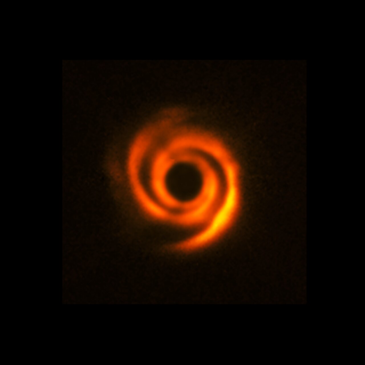 This image, captured with ESO’s Very Large Telescope (VLT), shows a spiral disc around the young star HD 135344B. The image, which was released in 2016, was obtained with the Spectro-Polarimetric High-contrast Exoplanet Research (SPHERE) instrument. Spiral features like these can be sculpted by planets, although this image doesn’t show evidence of companions orbiting HD 135344B. However, new observations at somewhat longer wavelengths, obtained with the Enhanced Resolution Imager and Spectrograph (ERIS) at the VLT, have found a possible young planet around this star. The central black circle corresponds to a coronagraph –– a device that blocks the light of the star to reveal faint details around it. Credit: ESO/T. Stolker et al.