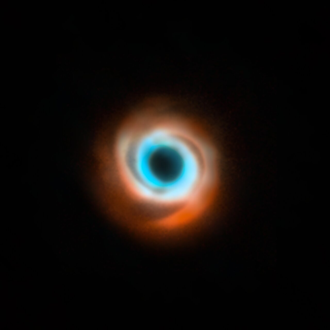 This image shows the dusty disc around the young star HD 135344B. It’s a combination of data taken with two different facilities: the Spectro-Polarimetric High-contrast Exoplanet Research (SPHERE) instrument at ESO’s VLT in red, and the Atacama Large Millimeter/submillimeter Array (ALMA) in orange and blue. The original SPHERE and ALMA images were released in 2016 and 2015 respectively and didn’t show evidence for the presence of a planet in this disc, first revealed in 2025. Credit: ESO/T. Stolker et al./ALMA (ESO/NAOJ/NRAO)/N. van der Marel et al.