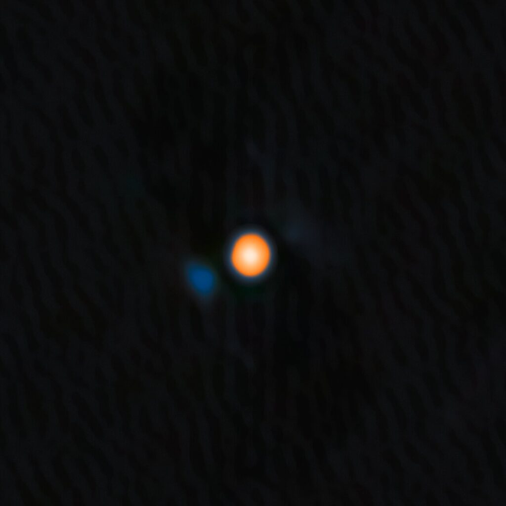 Using the NASA-NSF-funded ‘Alopeke instrument on the Gemini North telescope, one half of the International Gemini Observatory, partly funded by the U.S. National Science Foundation (NSF) and operated by NSF NOIRLab, astronomers have discovered a companion star in an incredibly tight orbit around Betelgeuse. This discovery answers the millennia-old question of why this famous star experiences a roughly six-year-long periodic change in its brightness, and provides insight into the physical mechanisms behind other variable red supergiants. The companion star appears blue here because, based on the team’s analysis, it is likely an A- or B-type star, both of which are blue-white due to their high temperatures.‘Alopeke is funded by the NASA-NSF Exoplanet Observational Research Program (NN-EXPLORE). Credit: International Gemini Observatory/NOIRLab/NSF/AURA Image Processing: M. Zamani (NSF NOIRLab)